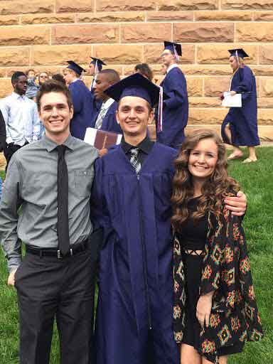 Senior Madi Koenig poses with her two older brothers after graduation.