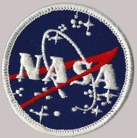The NASA badge glints, illuminating the bold red and blue threads of the nation’s premiere space exploration agency’s emblem. The patriotic colors of the logo are emphasized after the first all female space walk.