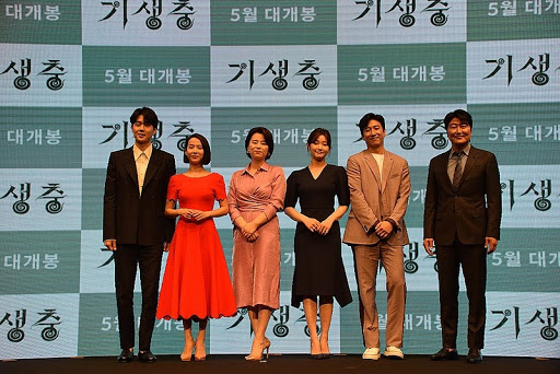 The cast of Parasite stands for a photo op at a press event. From left to right: Choi Woo-shik, Cho Yeo-jeong, Lee Jung-eun, Park So-dam, Lee Sun-kyun and Song Kang-ho.
