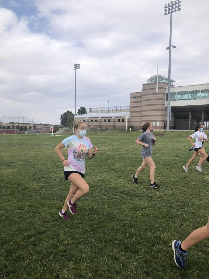 After school, Abby Snogren (12) warms up for cross country practice in her workout clothes along with the other 24 members of the team. I usually have to wear my clothes to fourth period to avoid the chaos in the bathroom, said Snogren.